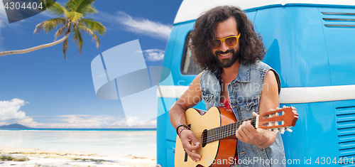 Image of hippie man playing guitar at minivan car on beach