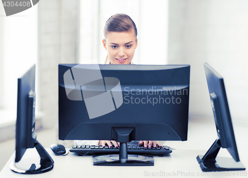 Image of businesswoman with computer and monitors in office