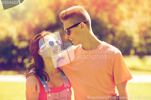 Image of happy teenage couple looking at each other in park