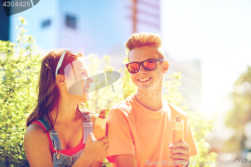 Image of happy teenage couple eating hot dogs in city