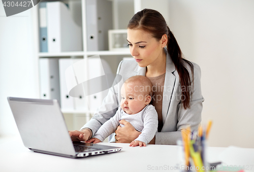 Image of happy businesswoman with baby and laptop at office