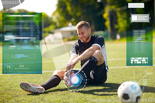 Image of injured soccer player with ball on football field