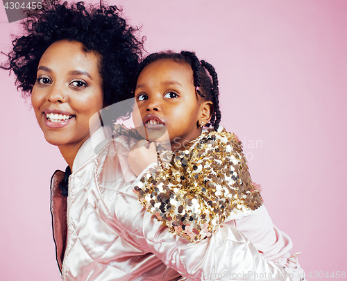 Image of young pretty african-american mother with little cute daughter hugging, happy smiling on pink background, lifestyle modern people concept 