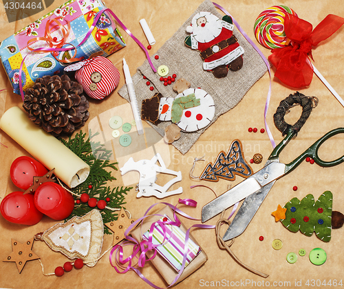 Image of handmade christmas gifts in mess with toys, candles, fir, ribbon, tree cone wooden vintage, post card view 