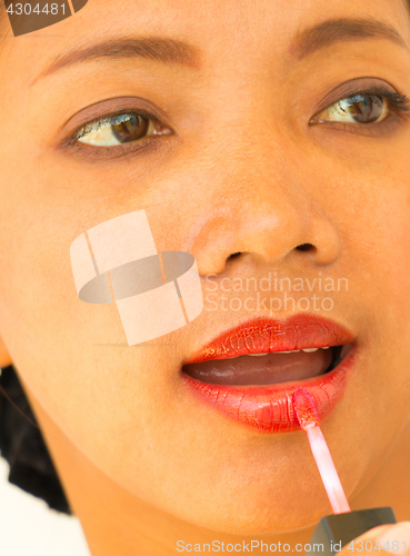 Image of Applying Lipgloss On Lips To Make Girl Beautiful