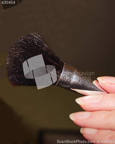 Image of makeup brush in hand