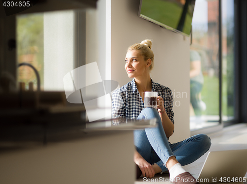 Image of young woman drinking coffee enjoying relaxing lifestyle