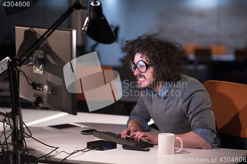 Image of man working on computer in dark startup office