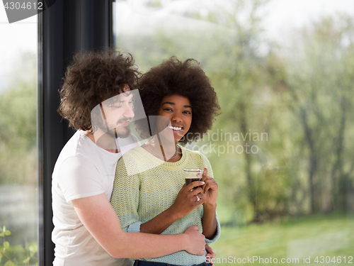 Image of happy multiethnic couple relaxing at modern home indoors