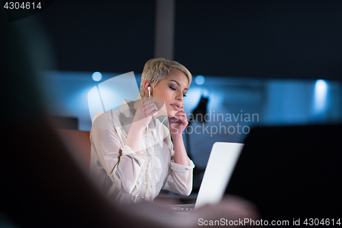 Image of woman working on laptop in night startup office