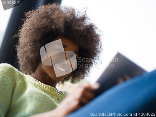 Image of young african american woman at home using digital tablet