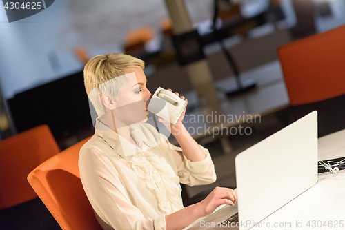 Image of woman working on laptop in night startup office