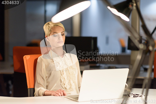 Image of woman working on laptop in night startup office