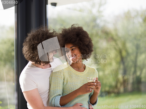 Image of happy multiethnic couple relaxing at modern home indoors