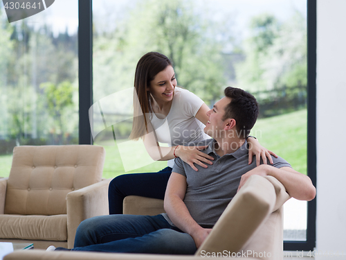 Image of young handsome couple hugging on the sofa