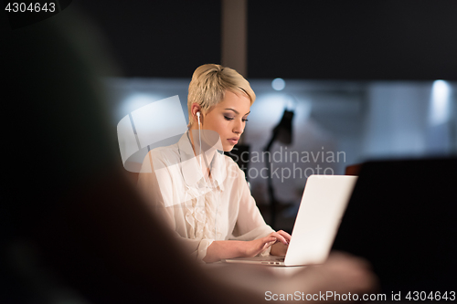 Image of woman working on laptop in night startup office