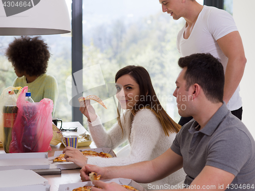 Image of multiethnic group of happy friends lunch time