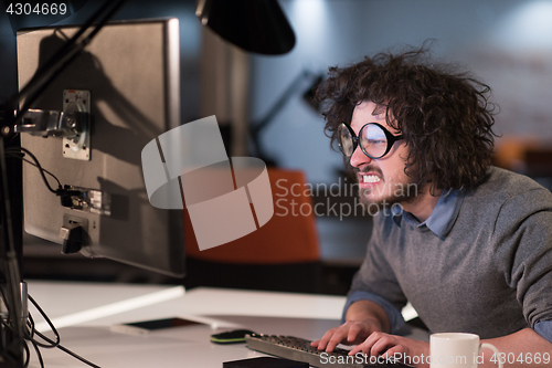 Image of man working on computer in dark startup office