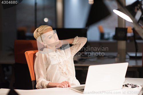 Image of woman working on laptop in night startup office