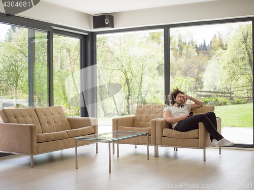 Image of young man using a mobile phone  at home