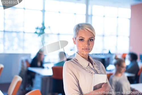 Image of woman working on digital tablet in night office