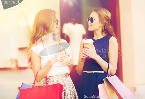 Image of young women with shopping bags and coffee at shop