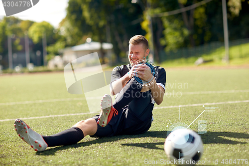 Image of injured soccer player with ball on football field