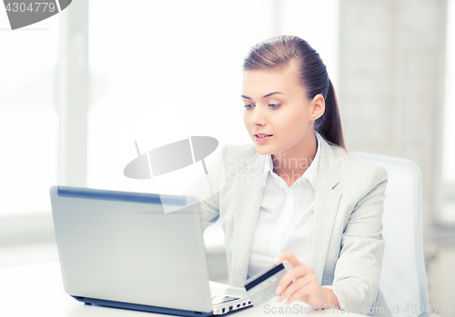 Image of businesswoman with laptop using credit card