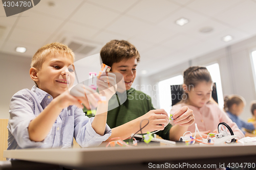 Image of happy children building robots at robotics school