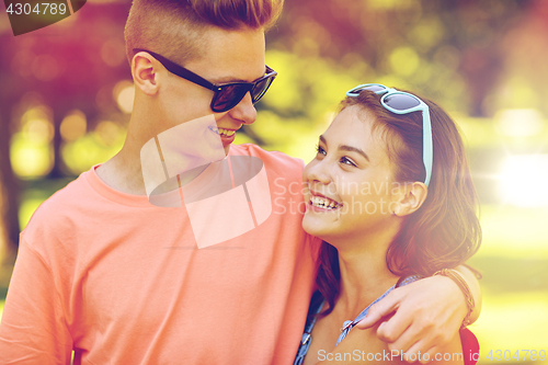 Image of happy teenage couple looking at each other in park