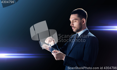 Image of businessman in suit with transparent tablet pc