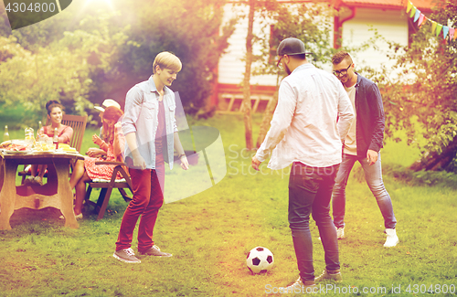 Image of happy friends playing football at summer garden