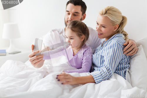 Image of happy family taking selfie by smartphone at home