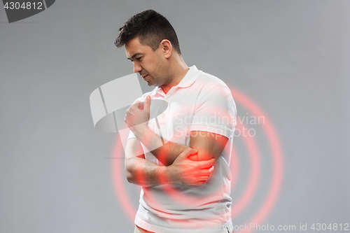 Image of unhappy man suffering from pain in hand