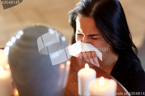 Image of woman with cremation urn at funeral in church