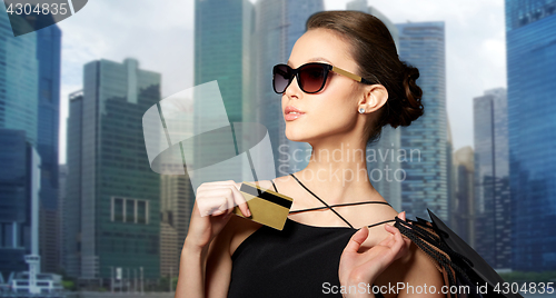 Image of happy woman with credit card and shopping bags