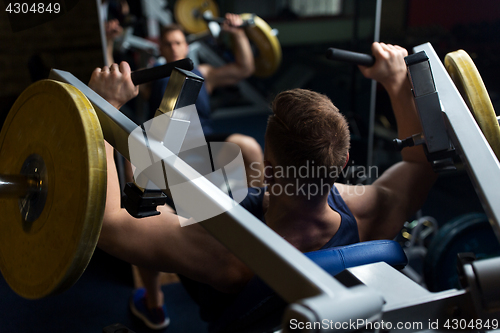 Image of man doing chest press on exercise machine in gym