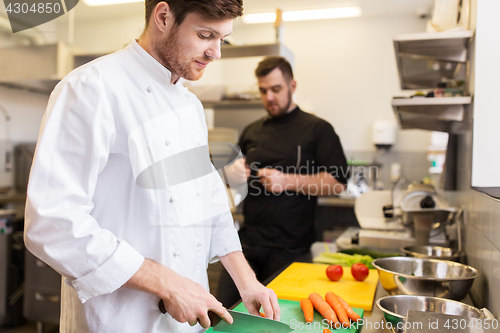 Image of chef and cook cooking food at restaurant kitchen