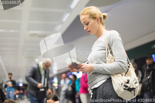 Image of Casual woman waiting for her flight at airport.