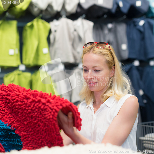 Image of Woman choosing the right item for her apartment in a modern home furnishings store.