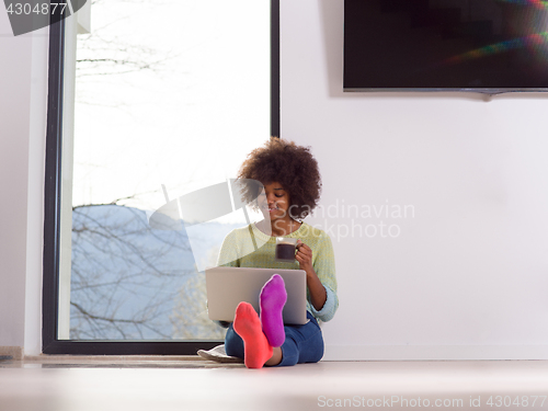 Image of black woman in the living room on the floor