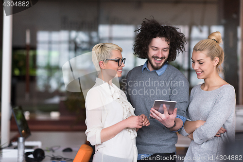 Image of group of Business People Working With Tablet in startup office