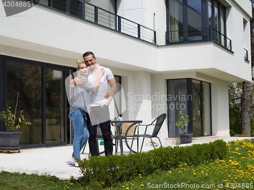 Image of couple hugging in front of  new luxury home