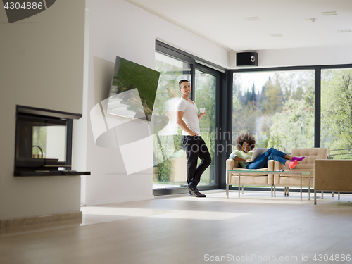 Image of multiethnic couple relaxing at  home with laptop computers