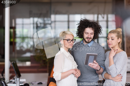 Image of group of Business People Working With Tablet in startup office