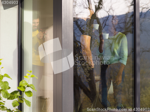 Image of happy multiethnic couple relaxing at modern home indoors