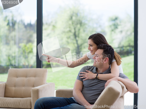 Image of young handsome couple hugging on the sofa