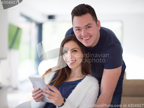 Image of couple using tablet at home