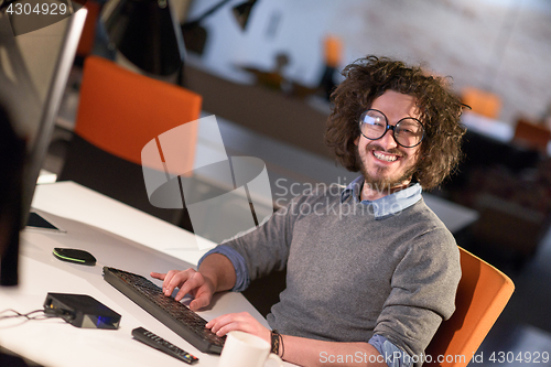 Image of man working on computer in dark startup office