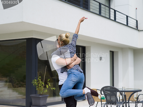 Image of couple hugging in front of  new luxury home